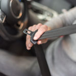 Man fastening seat belt in car